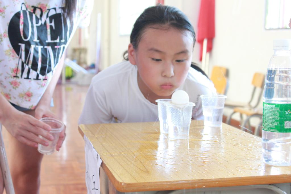 学生们在努力地吹水中的“乒乓球”